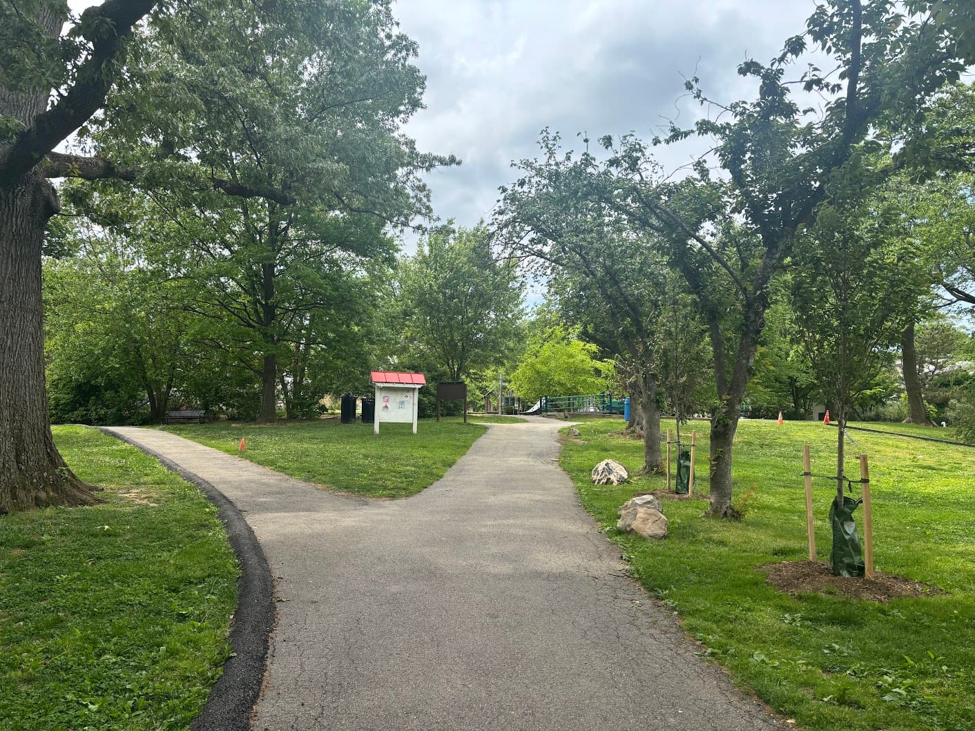 Path through trees toward the park playground